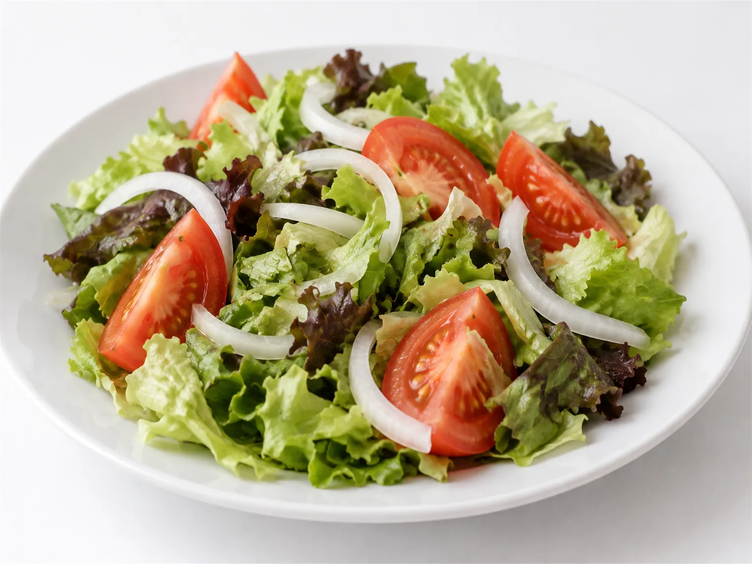 Option A: a mixed salad with lettuce, tomato and onion served on a white plate